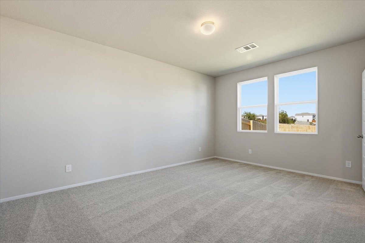 2714 Foss Road Manor, TX 78653 - Photo 16 of 34 Plush carpeting and natural light define this versatile, neutral-toned bedroom space.