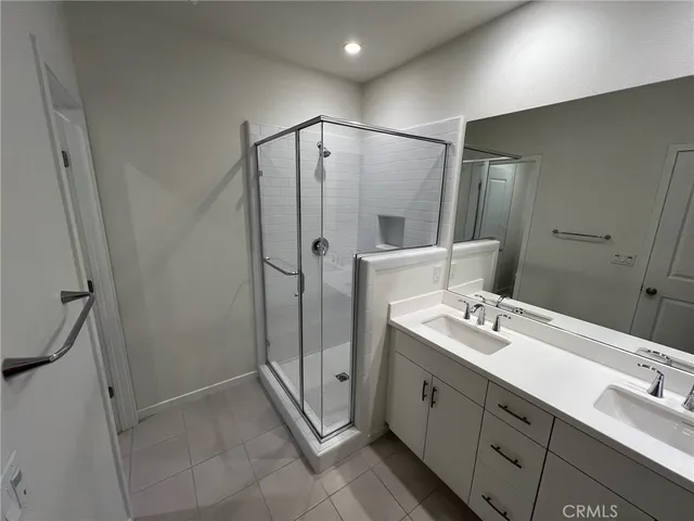 a spacious bathroom with a double vanity sink mirror and shower