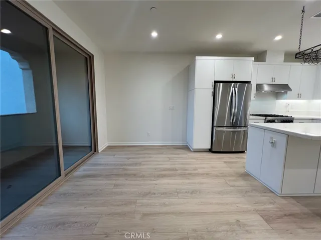 a kitchen with stainless steel appliances granite countertop a refrigerator and a stove