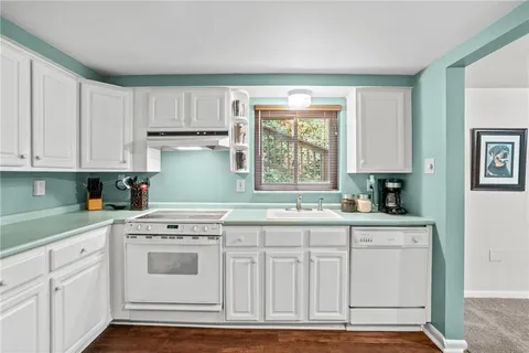 a kitchen with a sink cabinets and wooden floor