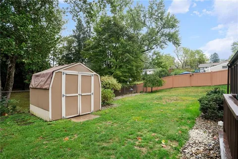 an aerial view of residential house with outdoor space and trees all around