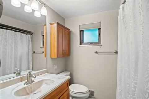 a bathroom with a sink vanity granite and toilet
