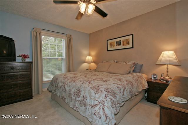 2442 Dean Road Jacksonville, FL 32216 - Photo 9 of 15 a bedroom with a bed and a lamp on dresser