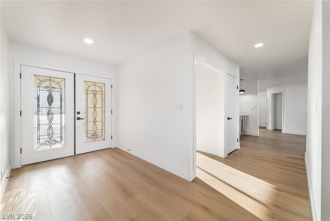 429 Crestway Road Henderson, NV 89015 - Photo 12 of 56 Ornate glass double doors welcome guests into this bright foyer with light wood flooring.