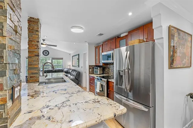 a kitchen with stainless steel appliances granite countertop a refrigerator and a stove top oven