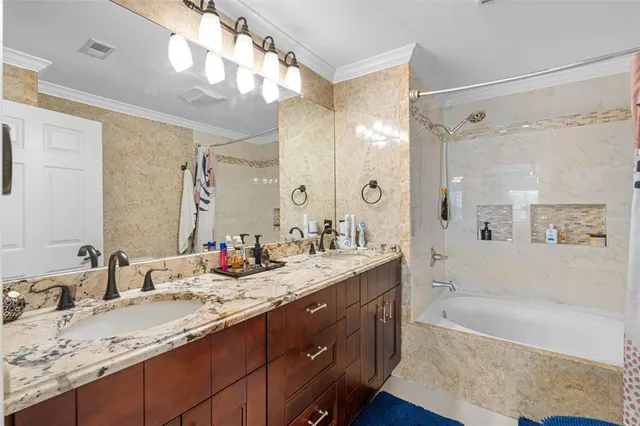 a bathroom with a granite countertop sink mirror and a bath tub