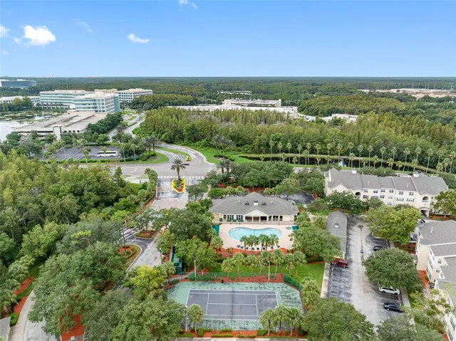 an aerial view of a city with lots of residential buildings ocean and mountain view in back
