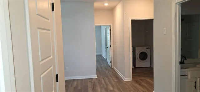 a view of a hallway with wooden floor and closet