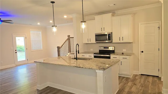 a kitchen with kitchen island granite countertop stainless steel appliances and wooden cabinets