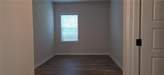 a view of a room with wooden floor and a window