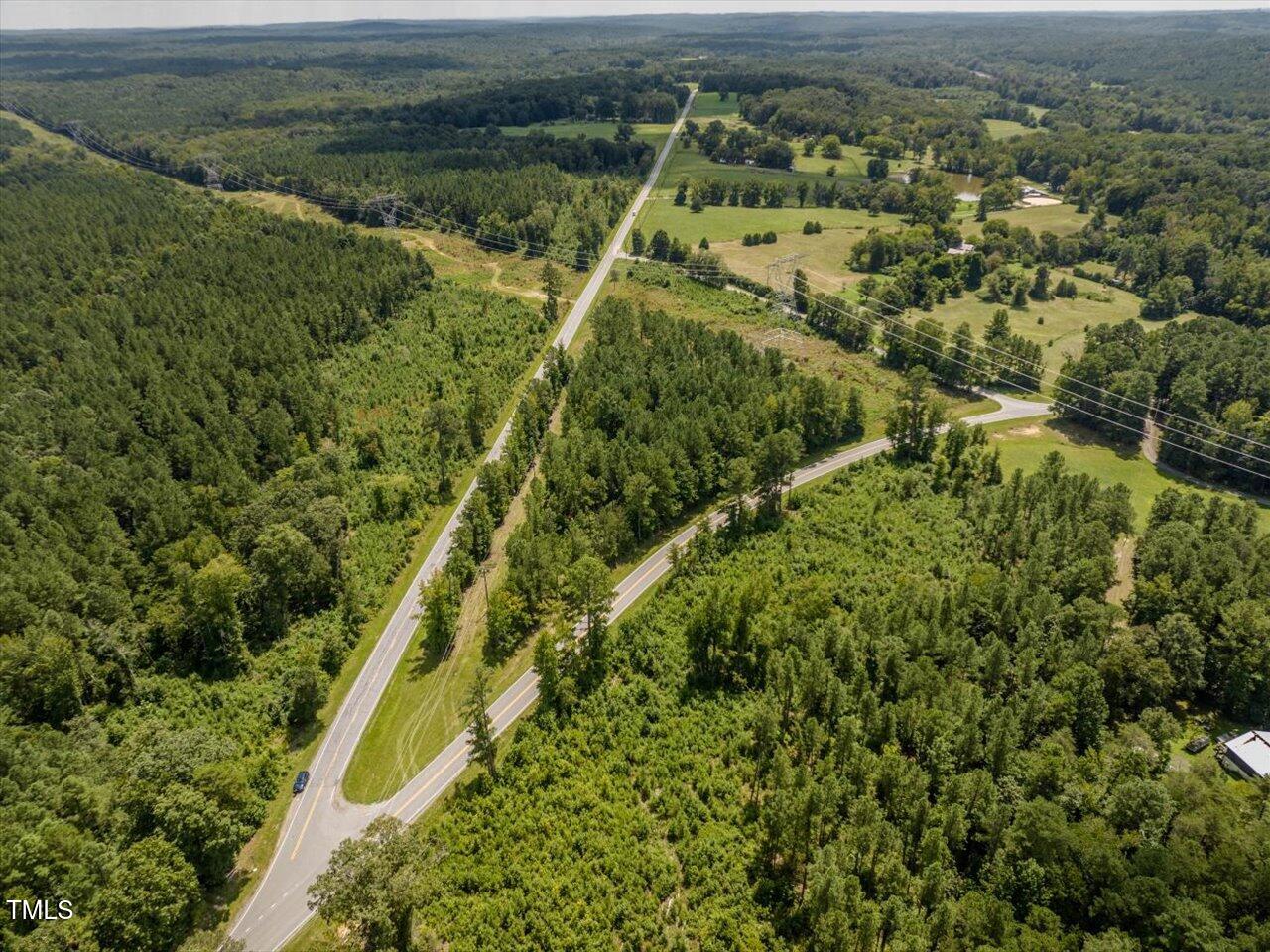 an aerial view of residential houses with outdoor space and trees
