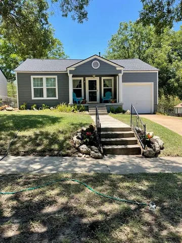a front view of a house with a garden and porch