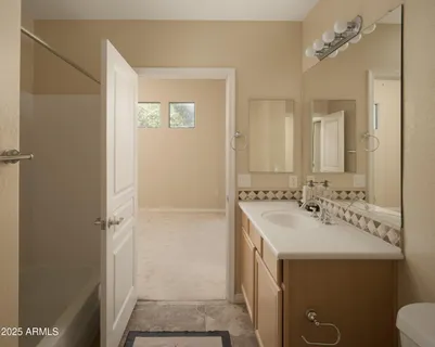 a bathroom with a sink a toilet a mirror and shower