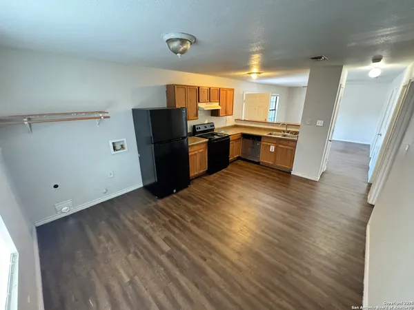 a kitchen with stainless steel appliances a refrigerator and a wooden floor