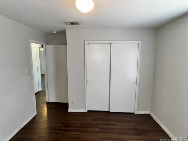 a view of an empty room with wooden floor