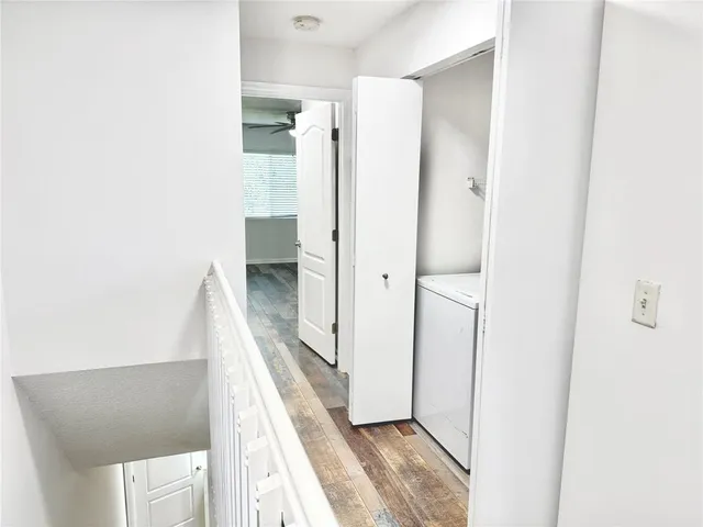 a view of a hallway with wooden floor and staircase