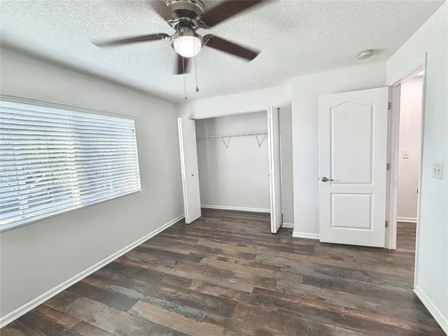 an empty room with a window and a ceiling fan