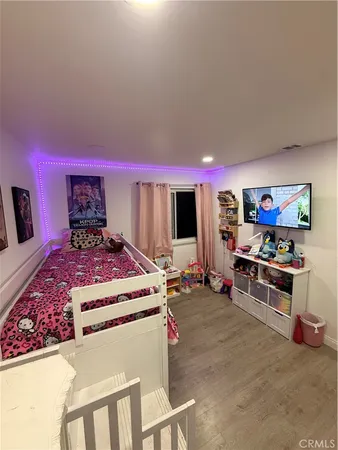 a living room with furniture a flat screen tv and a wall painting
