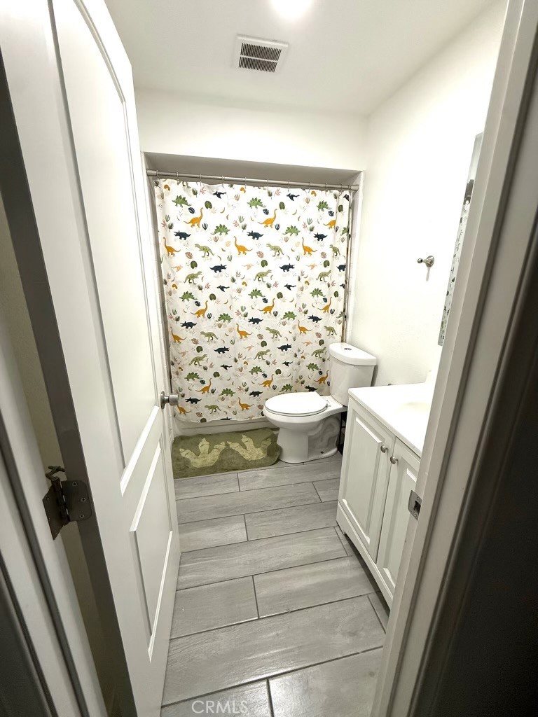 2606 North Palm Avenue Rialto, CA 92377 - Photo 16 of 29 a bathroom with a toilet and a shower curtain
