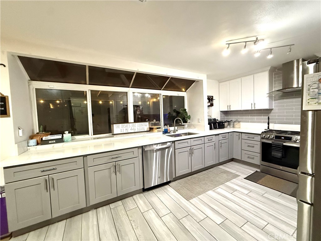 2606 North Palm Avenue Rialto, CA 92377 - Photo 23 of 29 a large kitchen with stainless steel appliances kitchen island granite countertop a sink and cabinets