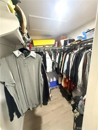 a view of walk in closet with clothes and shoes