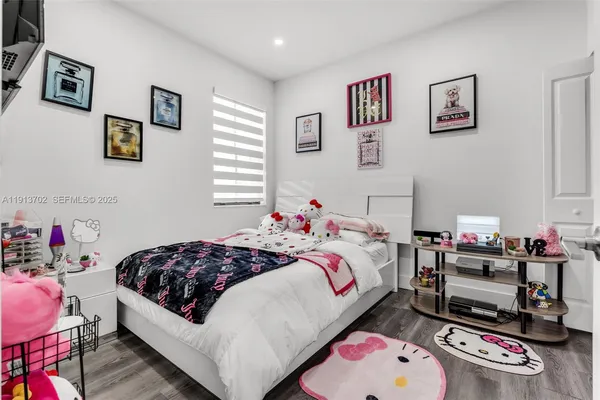 a bedroom with bed and wooden floor