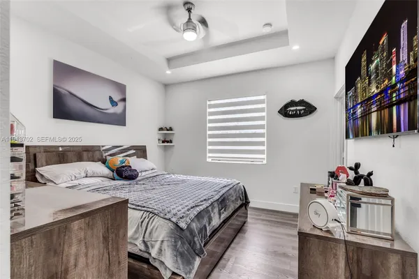a bedroom with a bed a dresser and next to a window