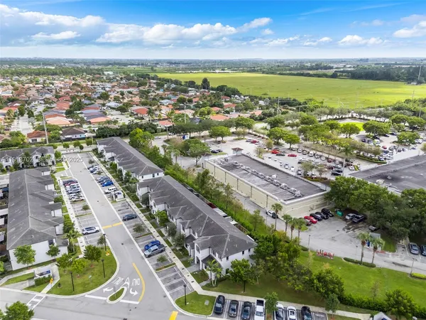 an aerial view of residential houses with outdoor space and ocean view