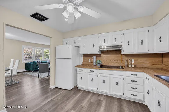 a kitchen with granite countertop white cabinets and white appliances