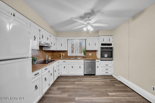 153 Cedar Swamp Road Jackson, NJ 08527 - Photo 10 of 21 a kitchen with granite countertop a refrigerator oven a sink dishwasher and white cabinets with wooden floor