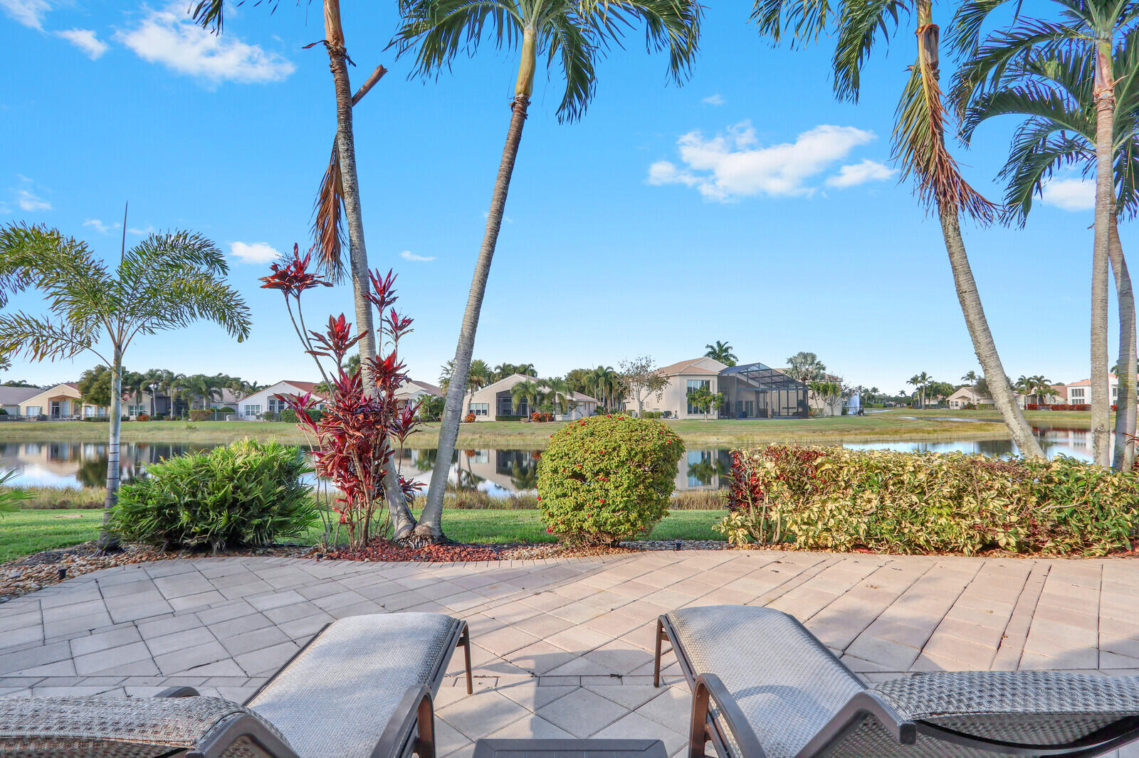 7349 Carmela Way Delray Beach, FL 33446 - Photo 42 of 82 a view of a lake with a palm tree and a lawn chair