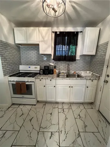 a kitchen with a sink a stove and cabinets