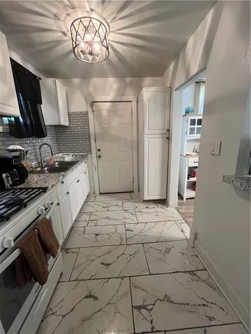 a kitchen with stainless steel appliances a stove refrigerator and cabinets