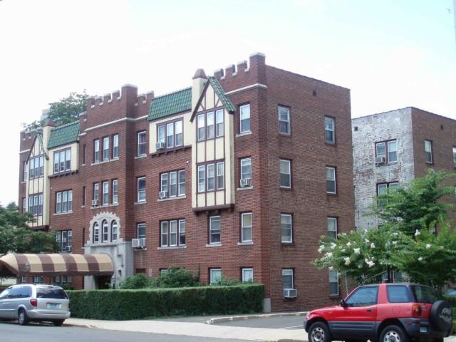 22 Glenbrook Road, Unit 416 Stamford, CT 06902 - Photo 1 of 1 a front view of a building with a yard and a car parked