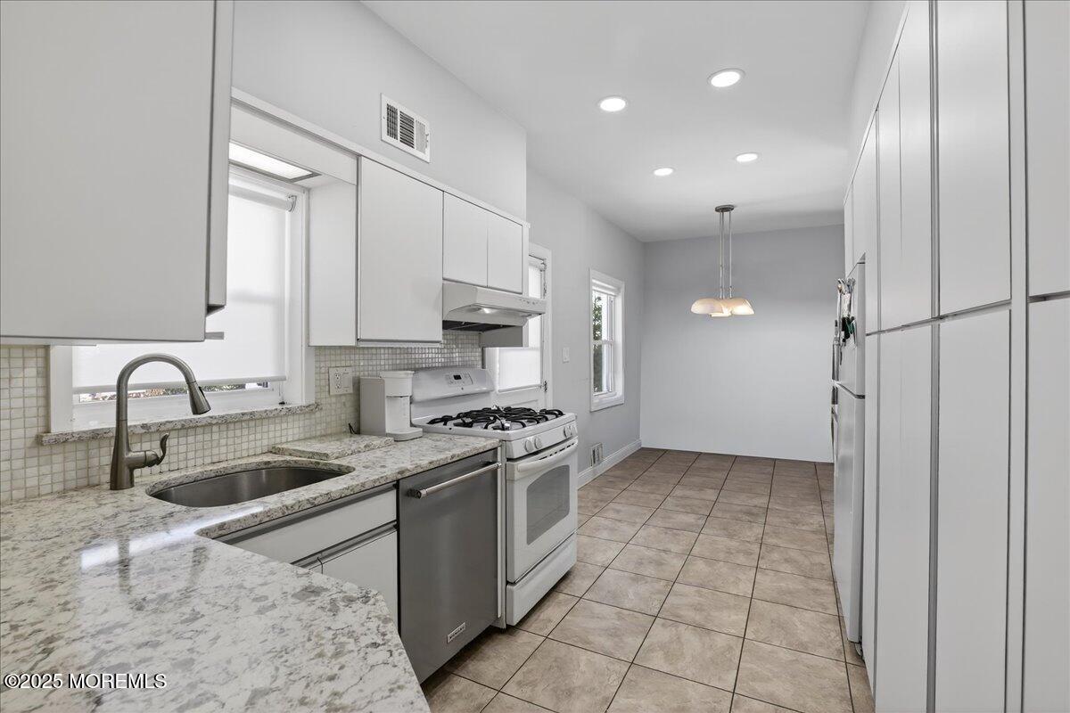57 Hathaway Avenue Deal, NJ 07723 - Photo 21 of 37 a kitchen with stainless steel appliances granite countertop a sink a stove and a refrigerator