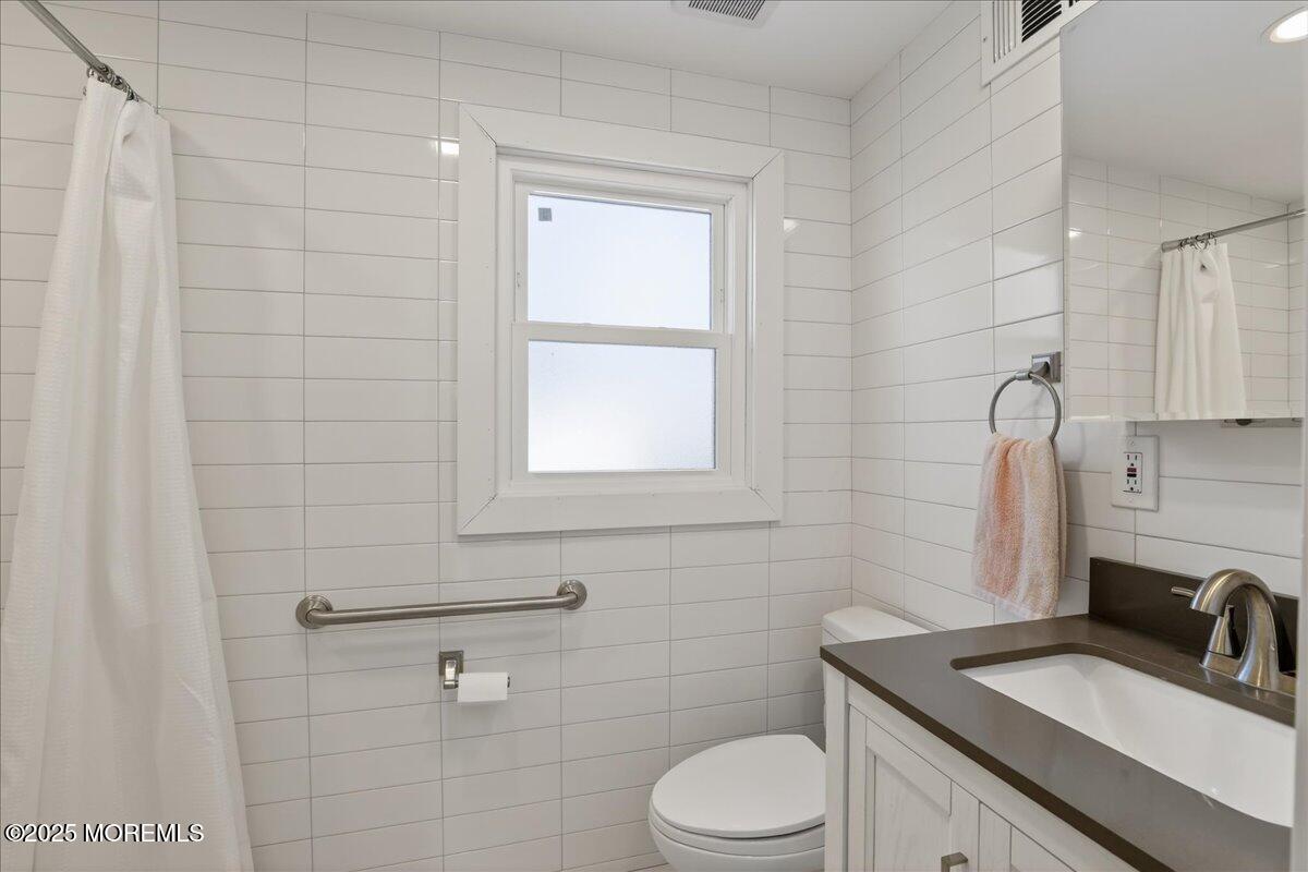 57 Hathaway Avenue Deal, NJ 07723 - Photo 30 of 37 a bathroom with a granite countertop sink toilet a mirror and shower