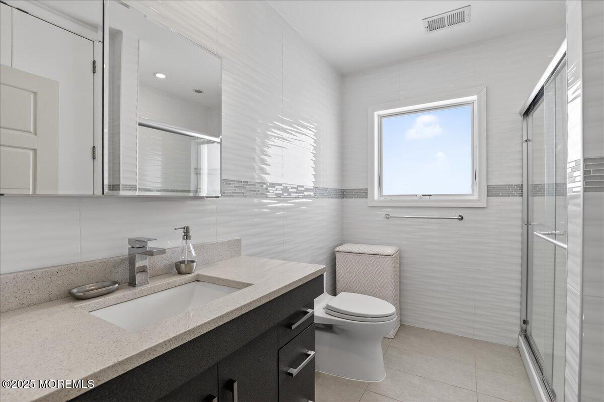 57 Hathaway Avenue Deal, NJ 07723 - Photo 36 of 37 a bathroom with a toilet a sink and mirror