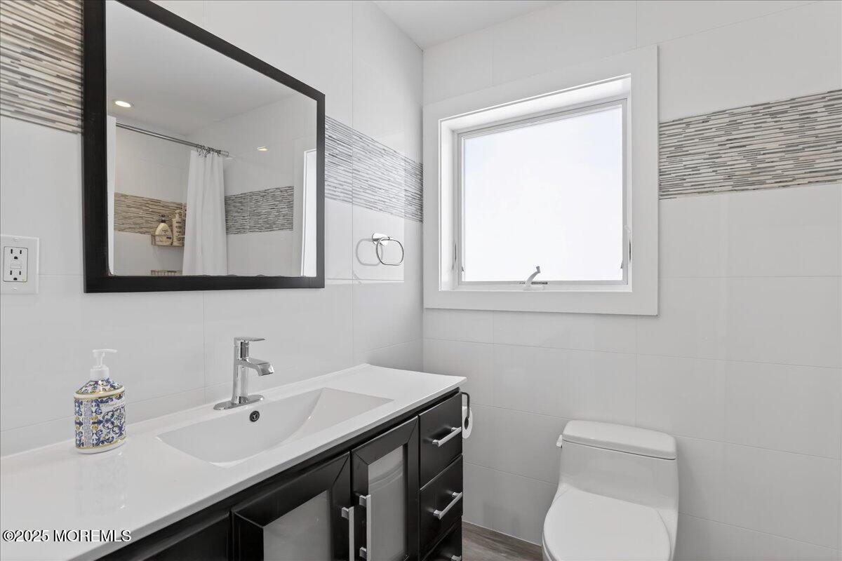 57 Hathaway Avenue Deal, NJ 07723 - Photo 9 of 37 a bathroom with a toilet a sink a mirror and a window