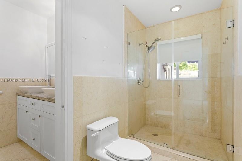 265 Glenridge Road Key Biscayne, FL 33149 - Photo 14 of 23 a bathroom with a granite countertop toilet a sink and shower