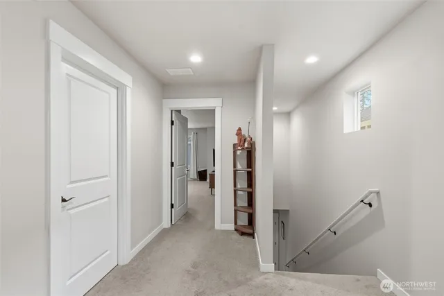 a view of a hallway with closet and a bathroom