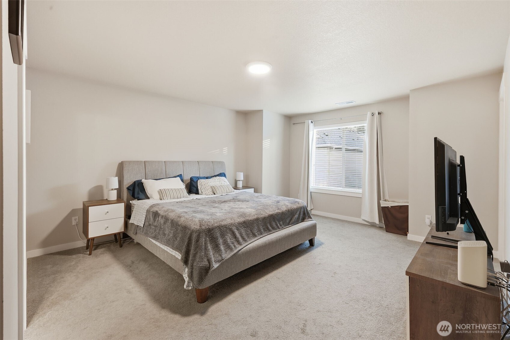 7109 South Ridge Way Ridgefield, WA 98642 - Photo 14 of 25 a spacious bedroom with a bed and a flat screen tv