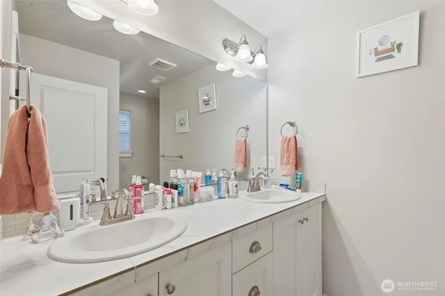a bathroom with a sink vanity and a mirror