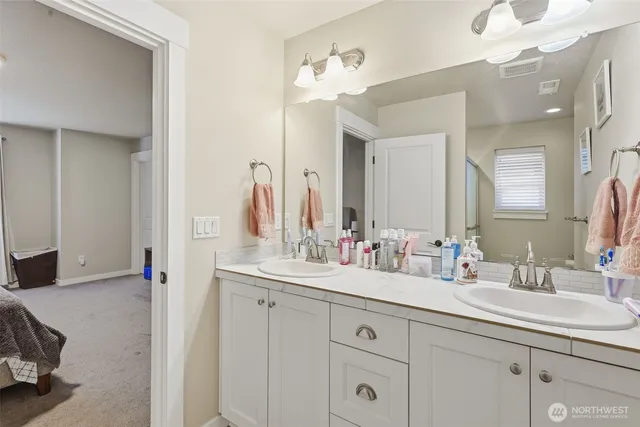 a bathroom with double sink and a mirror