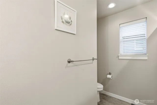 a bathroom with a toilet and a window