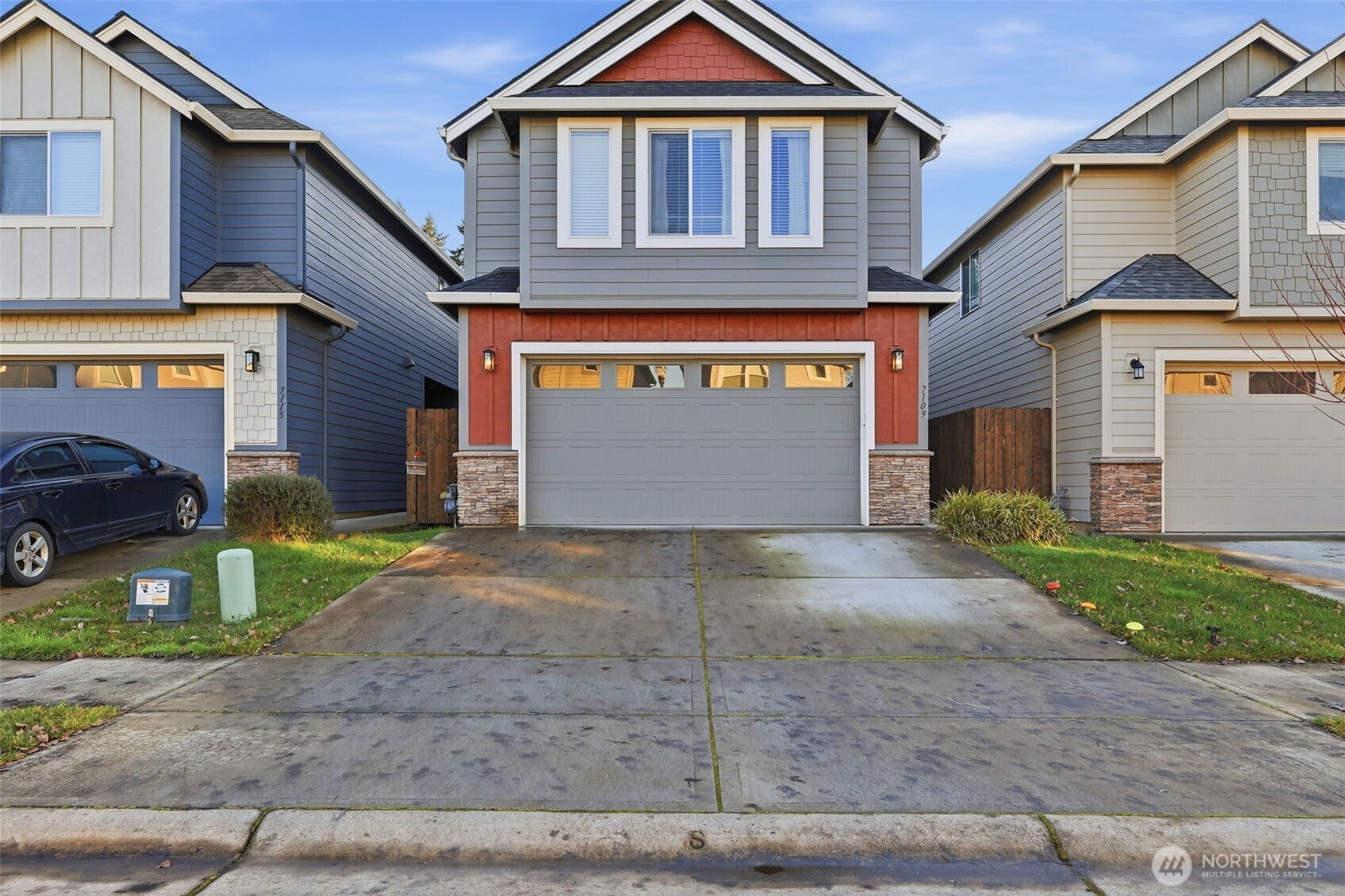 7109 South Ridge Way Ridgefield, WA 98642 - Photo 2 of 25 a front view of a house with a yard and garage