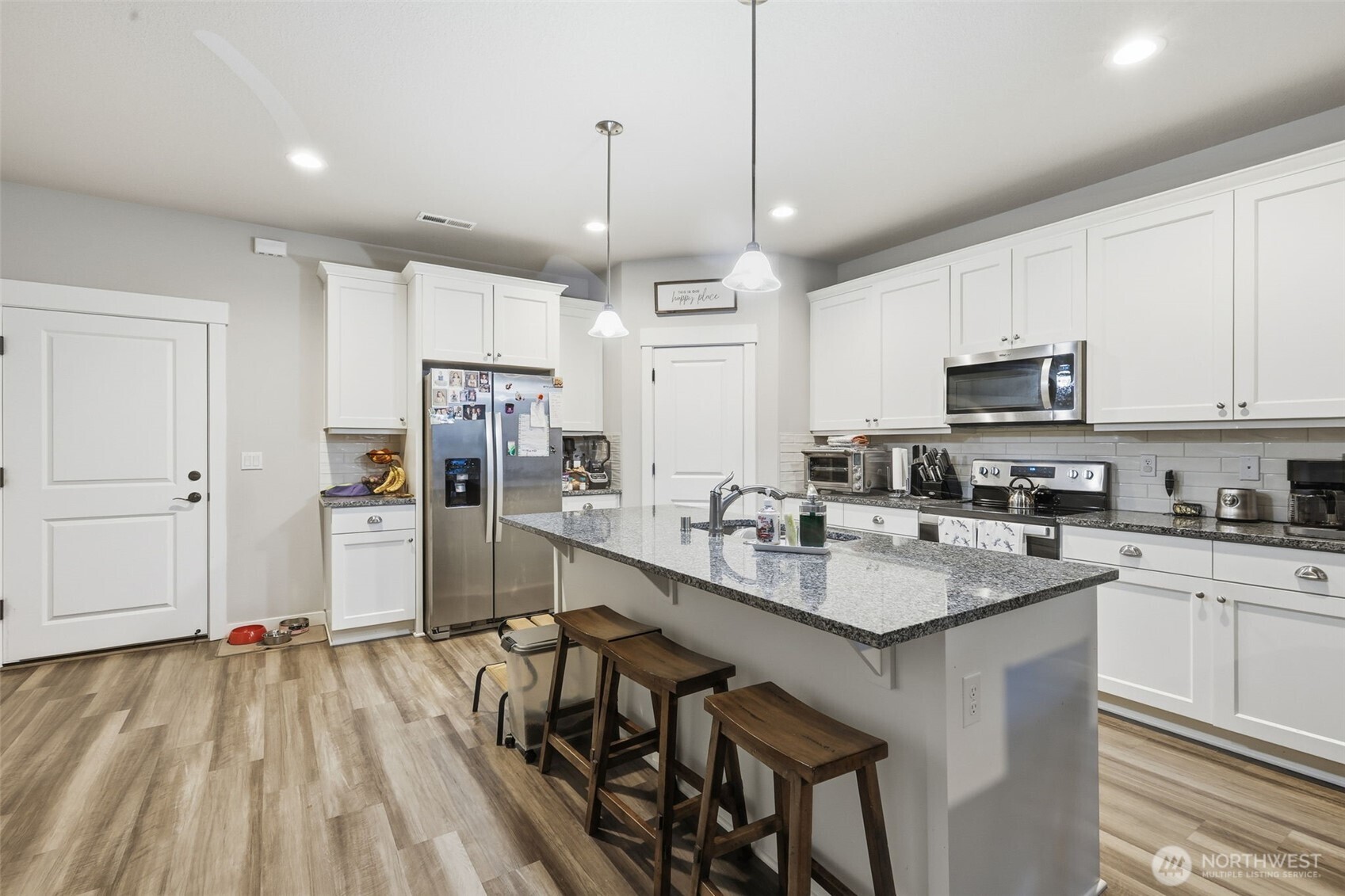 7109 South Ridge Way Ridgefield, WA 98642 - Photo 5 of 25 a kitchen with stainless steel appliances granite countertop a stove top oven a refrigerator a sink and a center island
