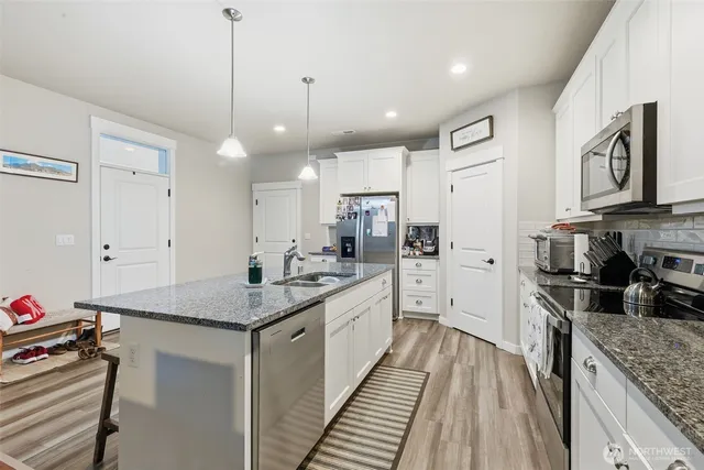 a kitchen with stainless steel appliances granite countertop a sink stove and refrigerator