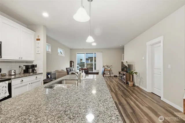 a living room with furniture a dining table and chairs with wooden floor
