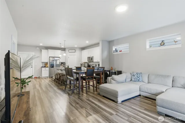 a living room with lots of furniture and a view of kitchen