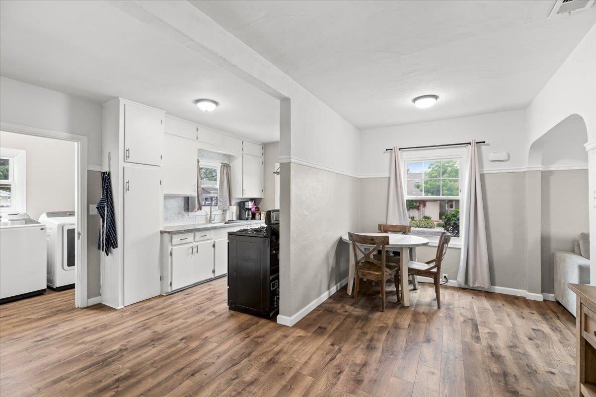 505 South Acacia Avenue Ripon, CA 95366 - Photo 16 of 38 a kitchen with stainless steel appliances a refrigerator a stove a sink dishwasher and a dining table with wooden floor